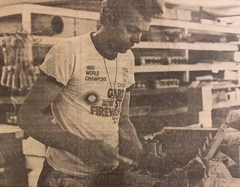 August Santore working at a shop bench in a Garden State Fireworks World Champions t-shirt, archival print