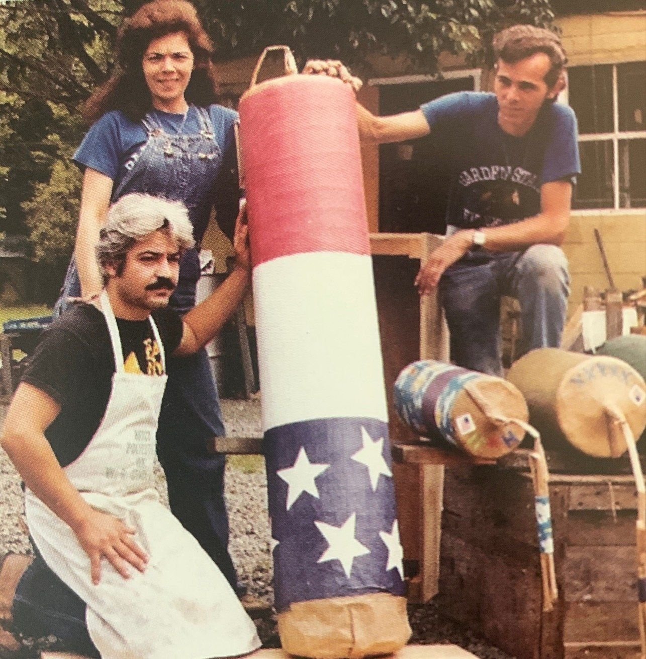 Frances, Nunzio and August posing outdoors with a tall red, white and blue star-patterned Monte Carlo shell