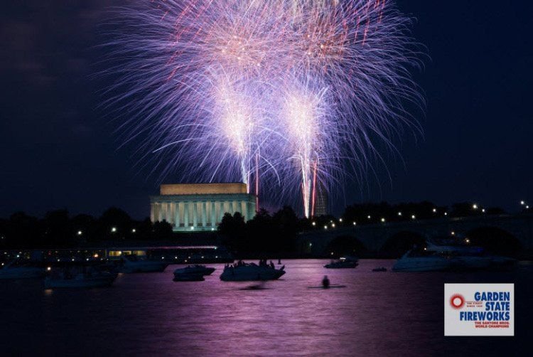 Purple and white fireworks over the Potomac and the Lincoln Memorial on July 4th, with boats on the water